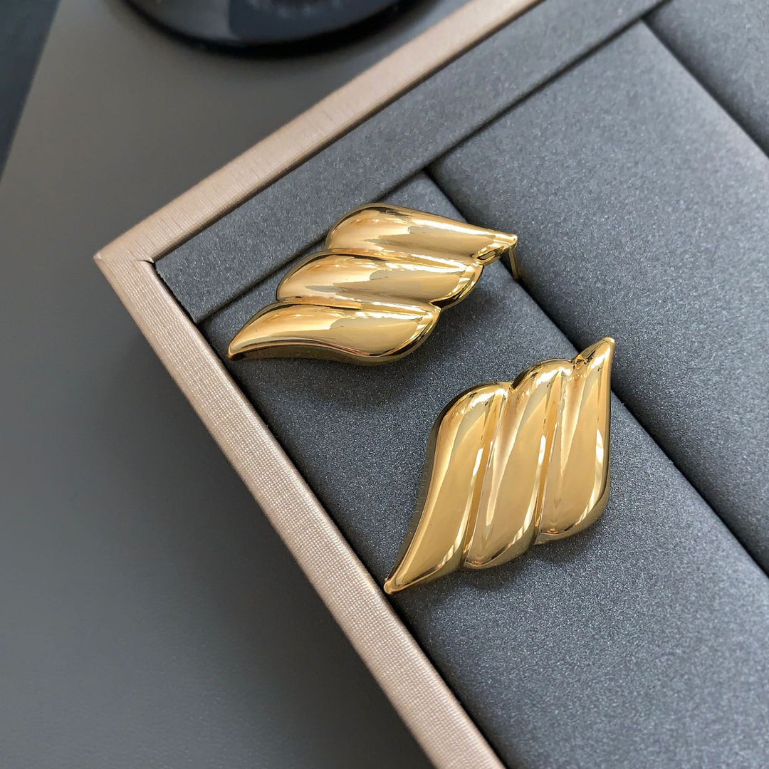 Polished wing-shaped stud earrings with sculpted curves - Ajurti