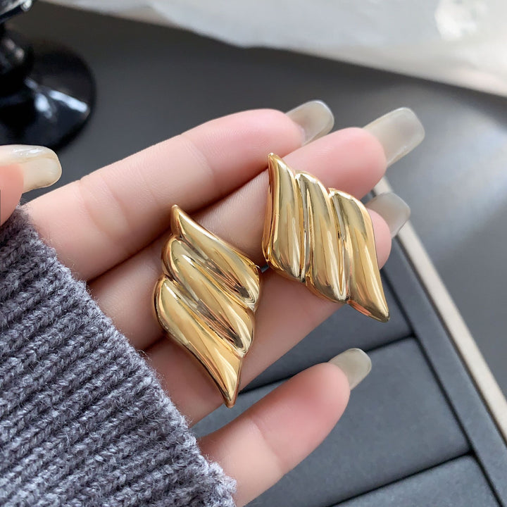 Polished wing-shaped stud earrings with sculpted curves - Ajurti