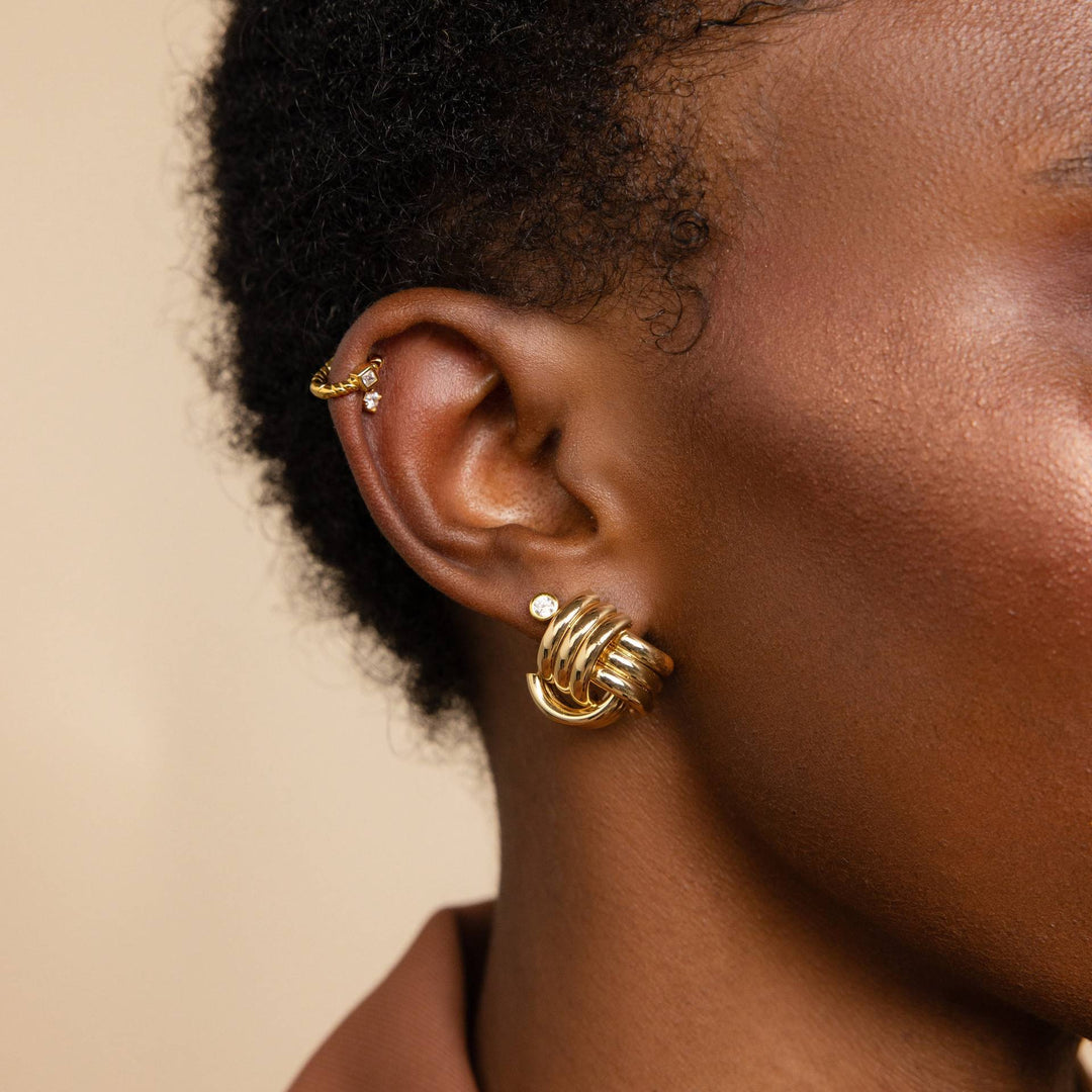 Ribbed twisted knot stud earrings in gold finish - Niguty