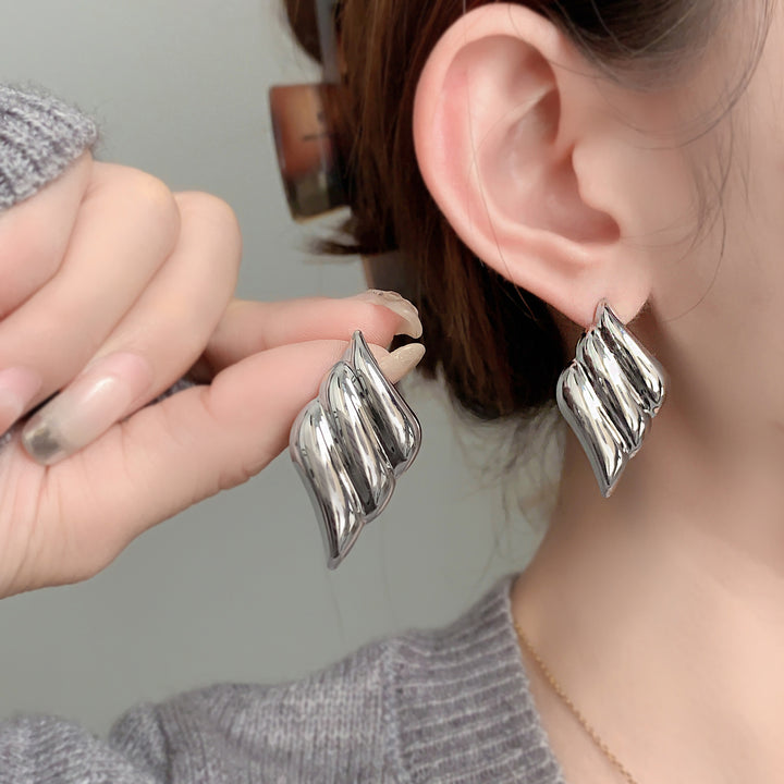 Polished wing-shaped stud earrings with sculpted curves - Ajurti