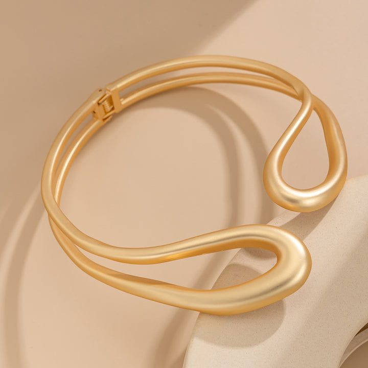 Twisted open metal choker with sculptural wave design - Dolkia