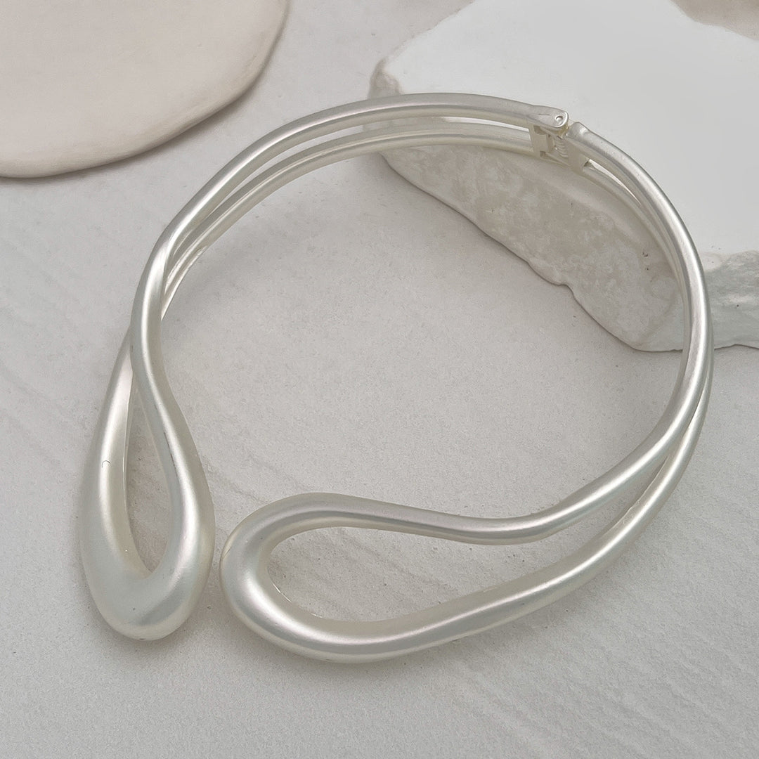 Twisted open metal choker with sculptural wave design - Dolkia